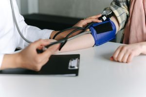 A healthcare worker uses a sphygmomanometer to check a patient's blood pressure in a medical office. — A Detailed Look of CBD