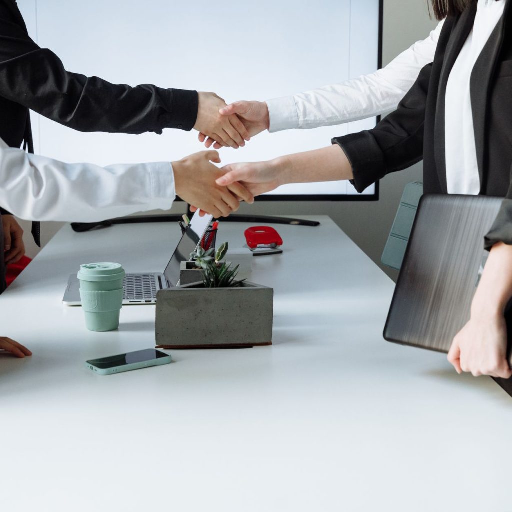 Professionals sealing a deal with a handshake across a conference table during a business meeting. — Addressing Common Myths