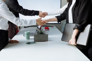Professionals sealing a deal with a handshake across a conference table during a business meeting. — Addressing Common Myths