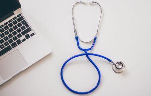 Medical stethoscope and laptop on a white desk, symbolizing digital health solutions. — An Informative Guide about Kratom and