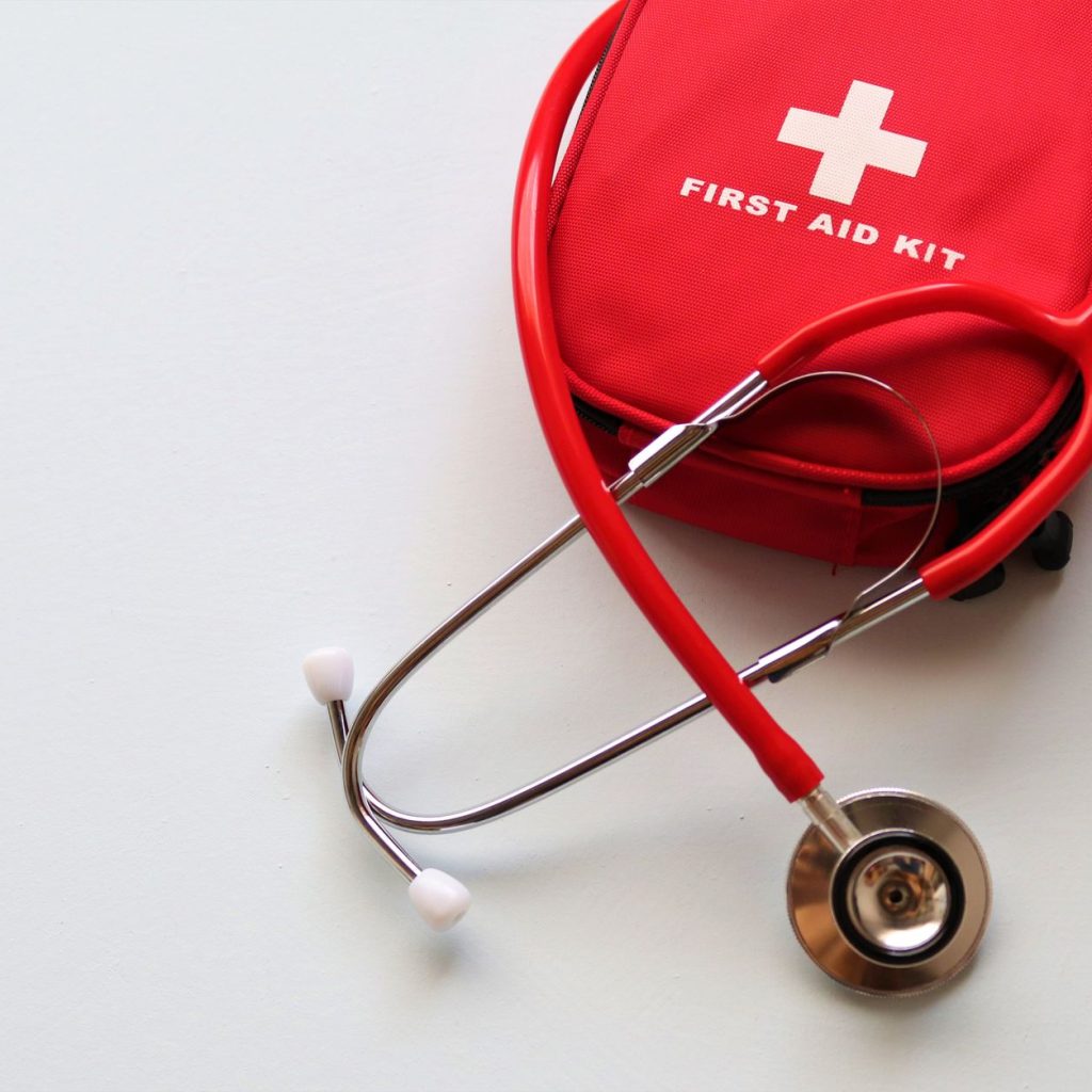 A red first aid kit paired with a stethoscope, signifying healthcare and medical treatment essentials. — AN INTRODUCTION TO C