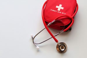 A red first aid kit paired with a stethoscope, signifying healthcare and medical treatment essentials. — AN INTRODUCTION TO C