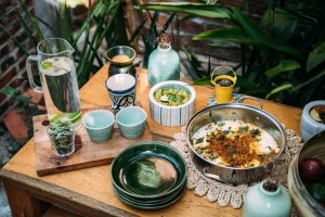 A colorful outdoor table setup with various dishes, cups, and a pitcher of water. — Best oil for Cooking for Bodybuilding