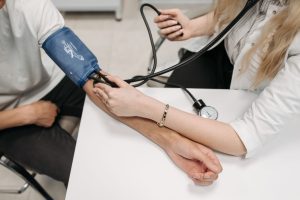 A doctor measures a patient's blood pressure with a sphygmomanometer during a consultation. — Can Rheumatoid Arthritis ever g
