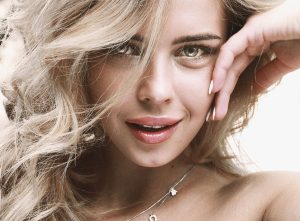 Captivating close-up of a young blonde woman smiling confidently, showcasing her natural beauty. — Choose a UPVC Conservatory