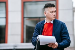 A serious man holding papers, dressed professionally in an urban environment. — Comparing Humana's 2024 Medicare Advantage Pl