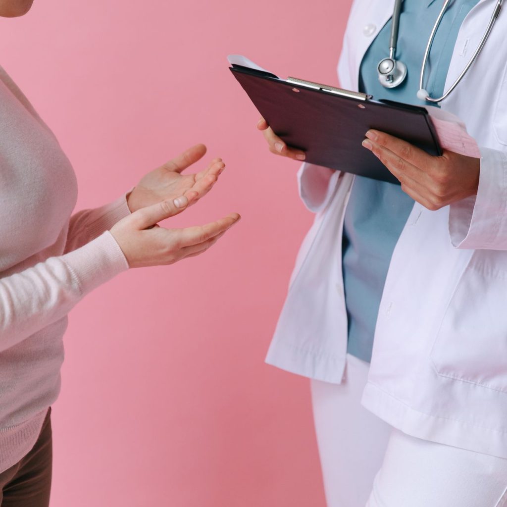 Close-up of a patient consulting a doctor with a clipboard in a medical setting. — Different types of LASIK