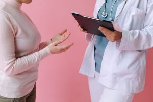 Close-up of a patient consulting a doctor with a clipboard in a medical setting. — Different types of LASIK