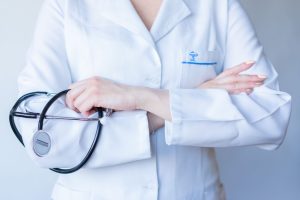 A close-up image of a doctor in a white coat with a stethoscope and arms crossed. — Different types of vape juice that you ca