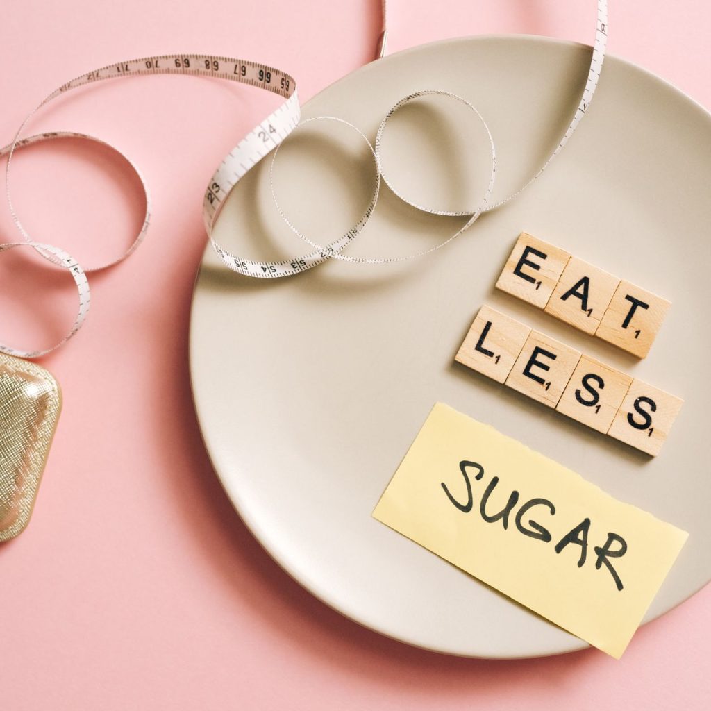 A conceptual image featuring a plate with messages made from Scrabble tiles and a tape measure, promoting healthy eating. — E