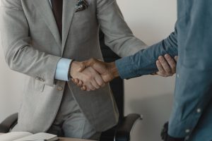 Image of a professional handshake between two businessmen in an office setting. — Feel Safe And Secure In ivy-glen Conway SC