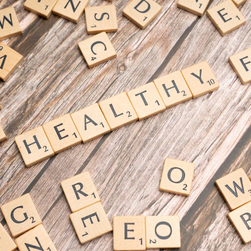 Wooden letter tiles arranged on a wooden surface spelling out 'healthy', symbolizing wellness. — Get large number of online c