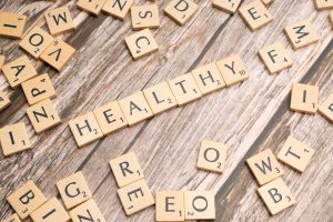 Wooden letter tiles arranged on a wooden surface spelling out 'healthy', symbolizing wellness. — Get large number of online c