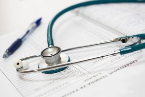 A stethoscope and pen resting on a medical report in a healthcare setting. — Great Choices for the Perfect Depression Thereap