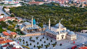 Vibrant aerial view of the iconic Mevlana Museum located in Konya, Türkiye, surrounded by lush greenery. — hi