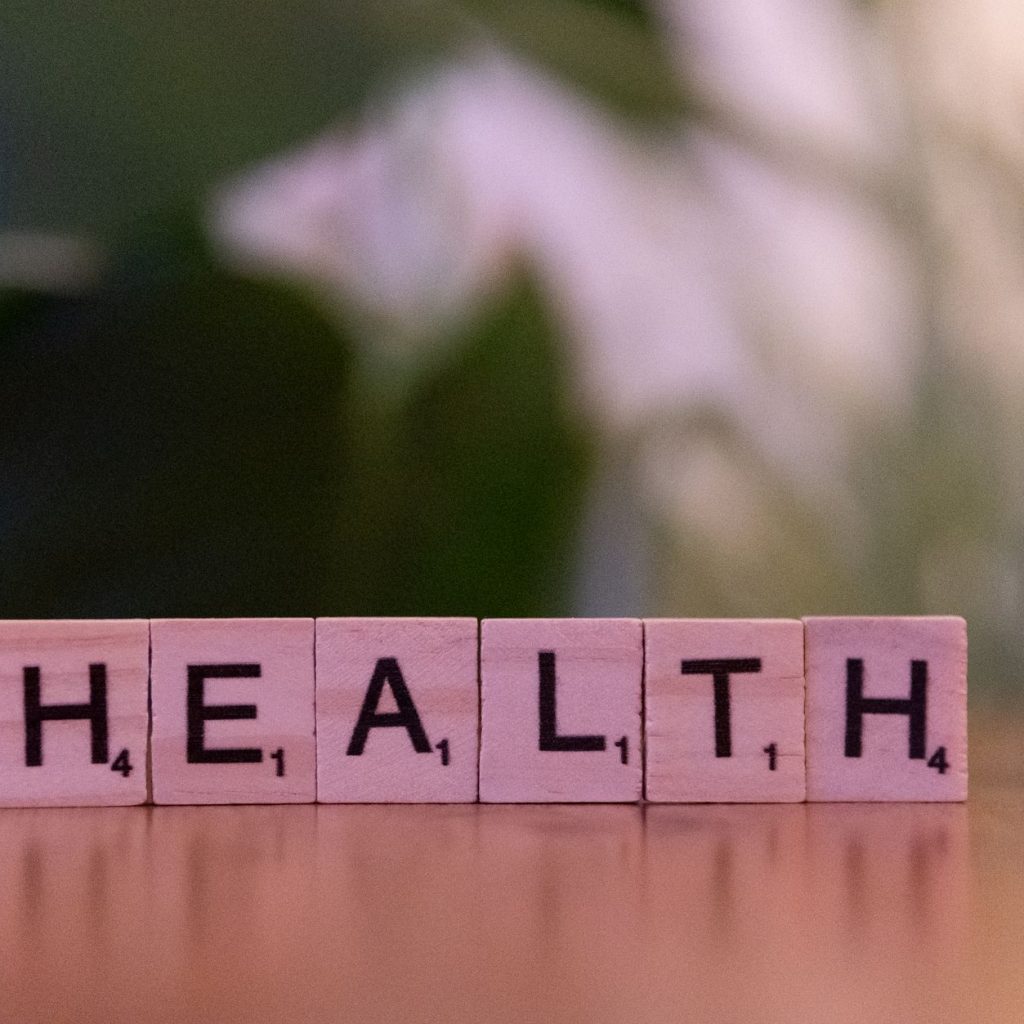 Close-up of Scrabble tiles spelling 'Health' on a wooden table with a blurred background. — How do muscle gainer supplements