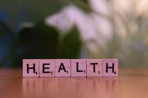 Close-up of Scrabble tiles spelling 'Health' on a wooden table with a blurred background. — How do muscle gainer supplements