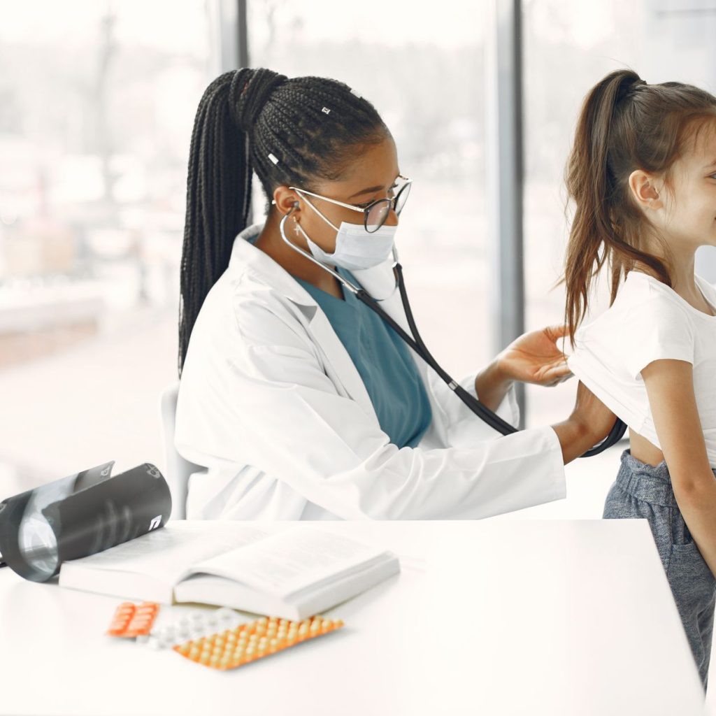 A female doctor gives a health check-up to a child in a bright clinic. — Is CBD Really a Non-Psychoactive Cannabinoid?