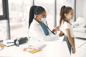 A female doctor gives a health check-up to a child in a bright clinic. — Is CBD Really a Non-Psychoactive Cannabinoid?
