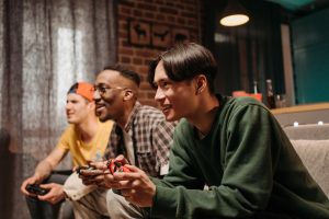 Diverse group of young adults enjoying video games together indoors, creating a fun and social atmosphere. — Make a Fortune w