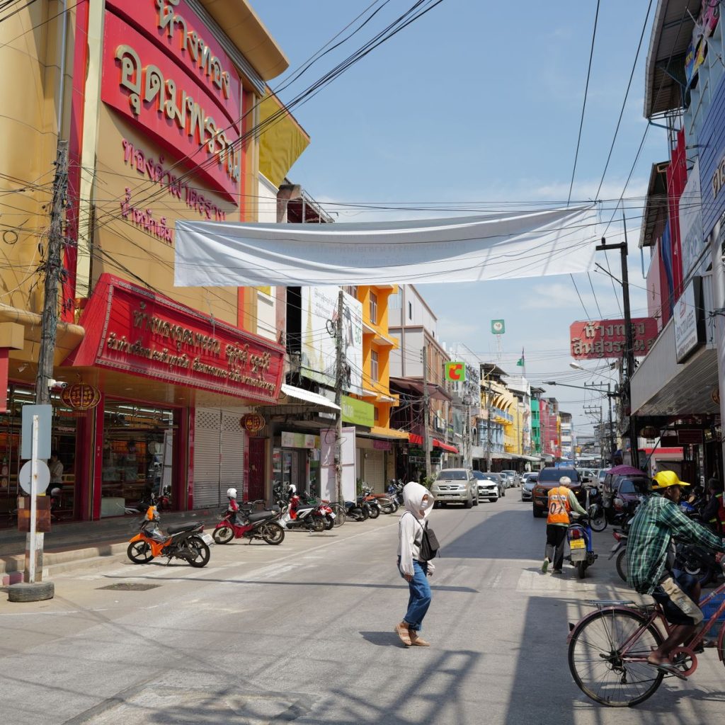 Lively urban street in Thailand with people, shops, and traffic under a sunny sky. — Mastering the Markets: Essential Insight