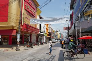 Lively urban street in Thailand with people, shops, and traffic under a sunny sky. — Mastering the Markets: Essential Insight