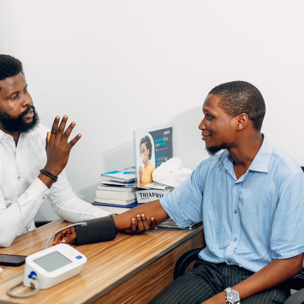 A medical professional consults with a patient during a blood pressure checkup in Lagos, Nigeria. — Post-acute Withdrawal Syn