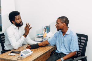 A medical professional consults with a patient during a blood pressure checkup in Lagos, Nigeria. — Post-acute Withdrawal Syn