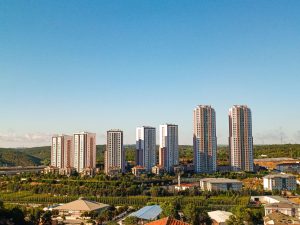 Aerial view of urban skyscrapers surrounded by greenery on a bright, clear day. — Safenote: Your Confidentiality Companion