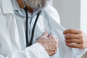 Close-up of a doctor adjusting a stethoscope while in a medical consultation. — Signs of an Addictive Personality