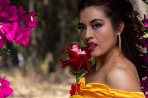 Woman in princess costume holding a flower, surrounded by vibrant blooms outdoors. — Smartest Options with the Best Shampoos