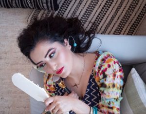 Portrait of a woman in vibrant attire looking in mirror, capturing elegance and style. — Some Great Hair Growth Aids For Heal