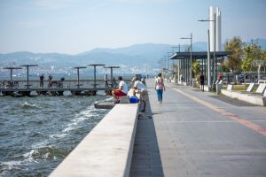 Serene seaside promenade with people fishing and strolling by the pier, set against coastal views. — The Basics of Online Rou