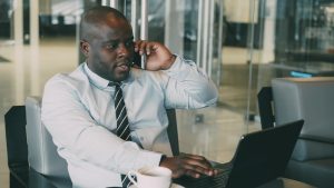 Professional man multitasking, talking on the phone while using a laptop in an office. — The Current Landscape of English Tea