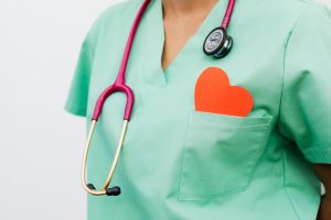 A healthcare professional with a stethoscope and red heart symbol emphasizes cardiology care. — Try an Online Yoga Class Toda