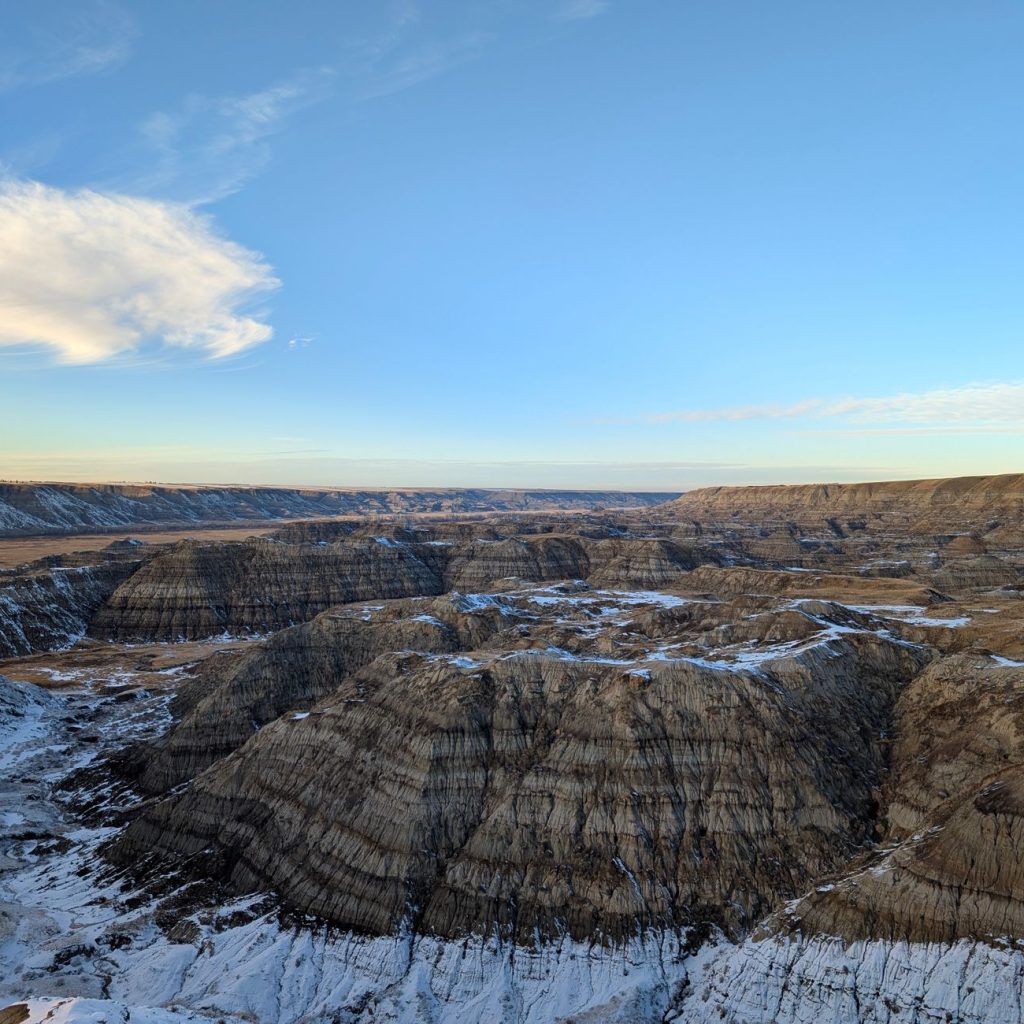 Wide view of the rugged Badlands landscape with snow patches under a clear blue sky. — Understanding Data Analytics in the Le