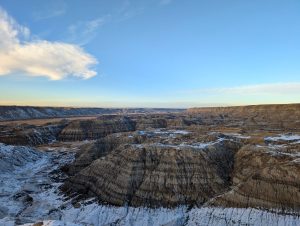 Wide view of the rugged Badlands landscape with snow patches under a clear blue sky. — Understanding Data Analytics in the Le