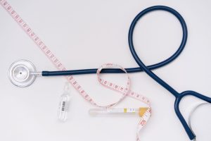 A stethoscope, ampoule, and tape measure on a white background symbolize healthcare essentials. — Using Cinnamomum Extract To