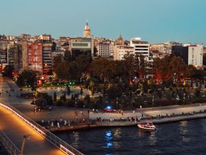 Scenic view of Istanbul's skyline featuring Galata Tower and bustling park at twilight along the waterfront. — What Are the M