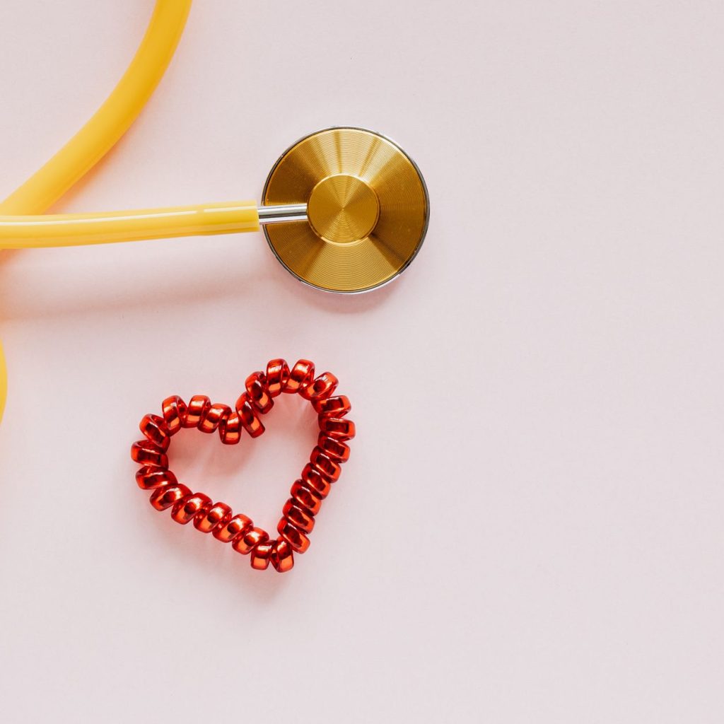 From above of yellow stethoscope near small red bead heart made for San Valentines Day on pale pink surface — What is migrain