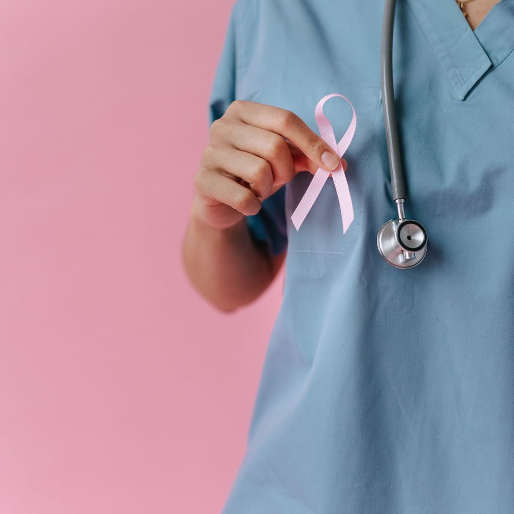 Healthcare worker in scrubs holds a pink breast cancer awareness ribbon symbolizing support. — What To Do If You Think Your L