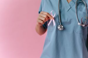 Healthcare worker in scrubs holds a pink breast cancer awareness ribbon symbolizing support. — What To Do If You Think Your L