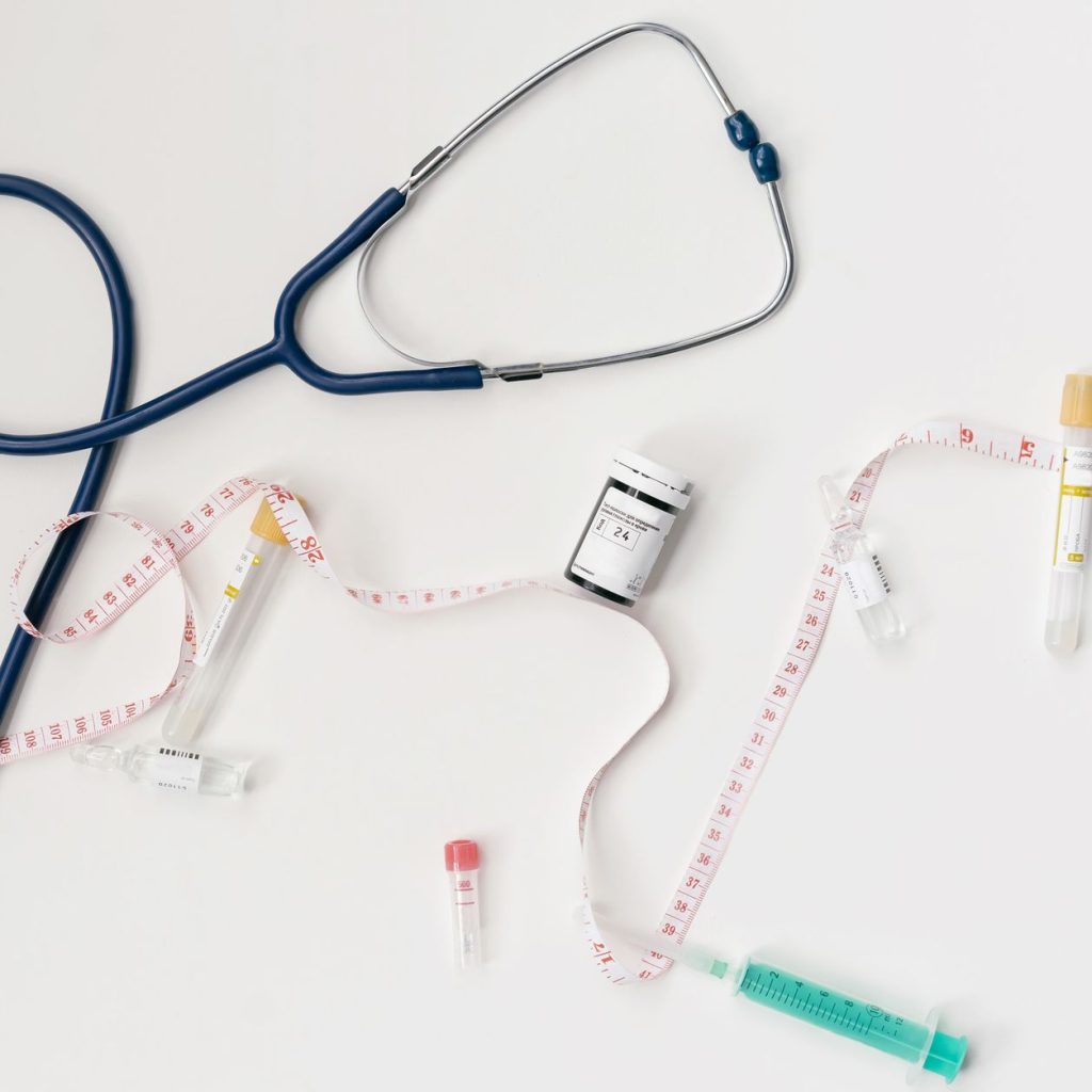 Top view of stethoscope, syringes, and tape measure on white background. — What to Expect During Your Hospital Emergency Room