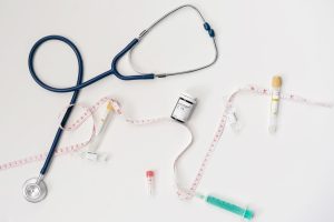 Top view of stethoscope, syringes, and tape measure on white background. — What to Expect During Your Hospital Emergency Room