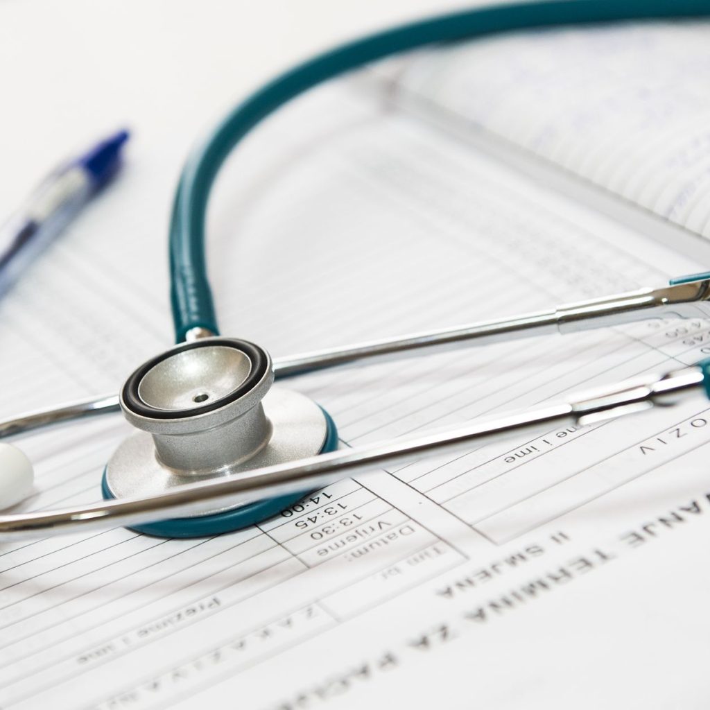A stethoscope and pen resting on a medical report in a healthcare setting. — Why Should I Order My Weed Edibles from Online O